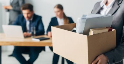 Employee carrying a box of belongings out of an office