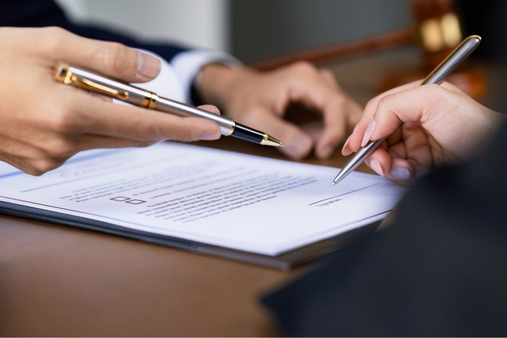 Two people reviewing and signing a written agreement