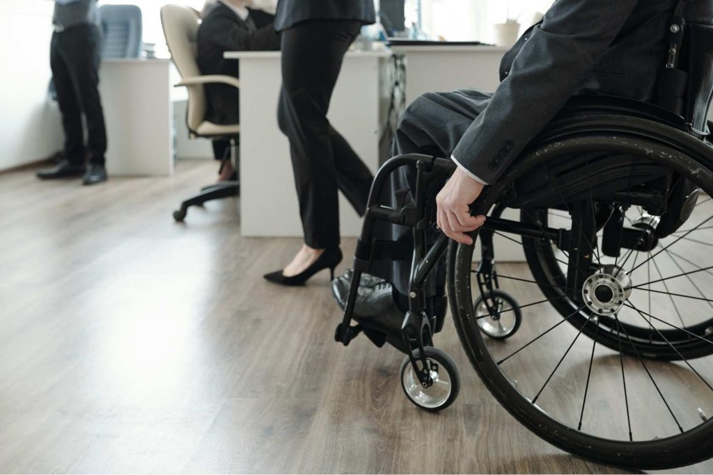 Wheelchair user alongside colleagues in a workplace